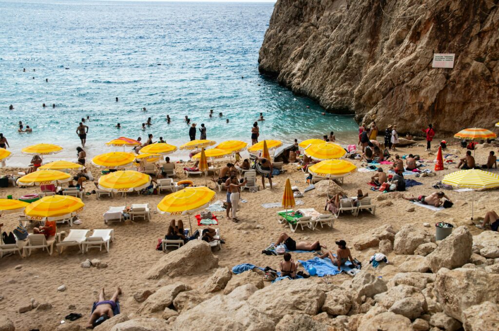 Переполненный пляж с желтыми зонтиками - наглядный пример того, как раннее получение визы помогает избежать очередей в пик сезона.