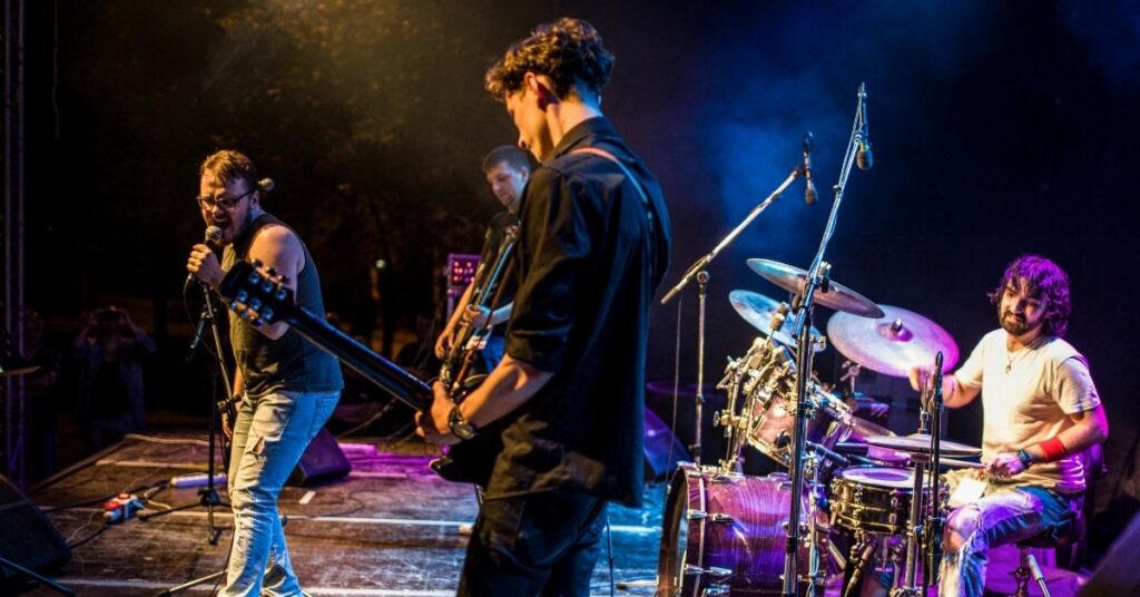 Band performing live on stage—example of on stage performances and music concerts covered under the c7a music performer visa, with crew on c7b.