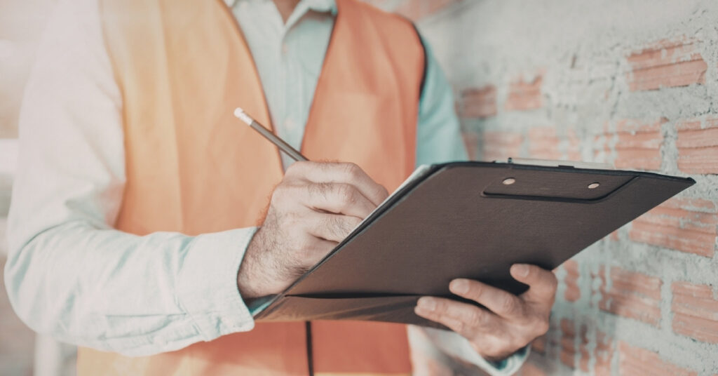 Site inspector with a clipboard checking technical reports for bali groundwater permit and reporting compliance