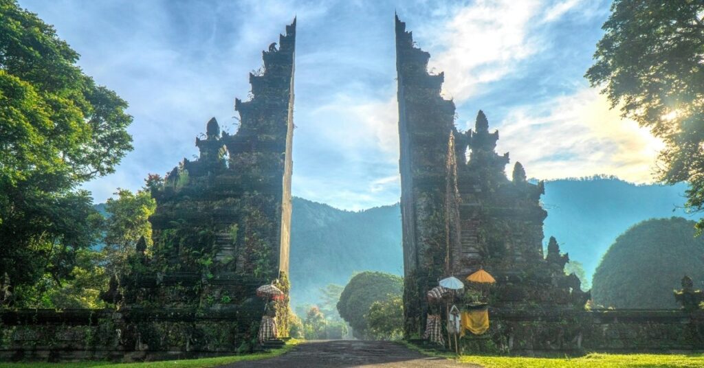 山々を背景にしたバリの象徴的な門は、バリの生活費とインドネシアの他の地域との比較を表すために使われている。