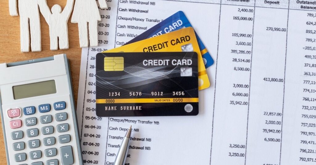 Karty kredytowe, kalkulator i długopis na wyciągu bankowym, symbolizujące dowód posiadania środków na podróż na Bali w 2026 roku.