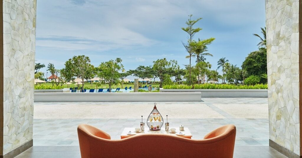 Nusa Dua resort lounge looking to manicured gardens and the sea, polished, five-star comforts.