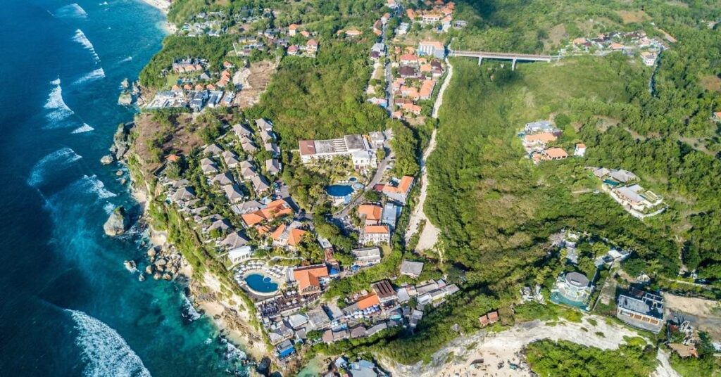 Aerial of Uluwatu’s cliffside villas and surf breaks, dramatic views and world-class waves.