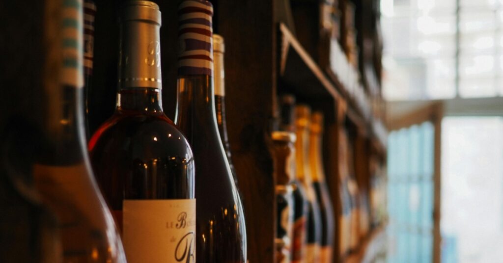 매장 진열대에 놓인 수입 와인 병, 여행객들이 발리 여행에 술을 가져오는 대신 고려할 수 있는 옵션을 보여줍니다.