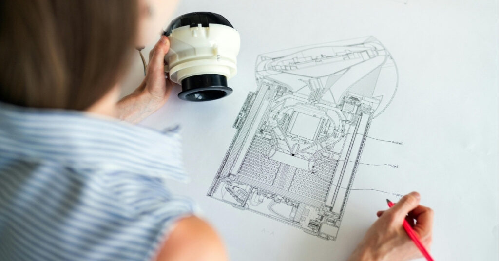 模型を手に技術図面を確認する建築家。バリの別荘建設におけるコンサルタントの役割を示している。