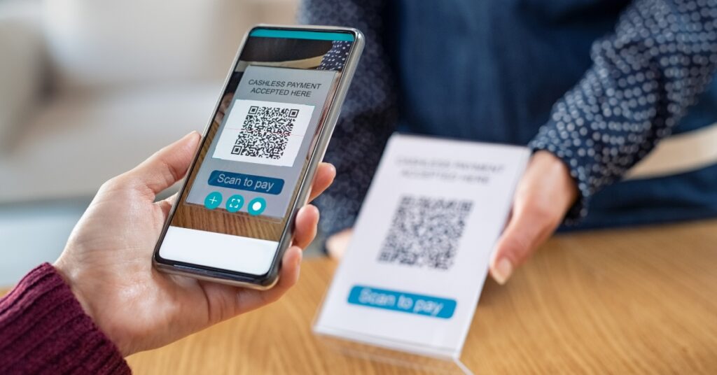 A person scanning a qr code with a smartphone to make a cross-border qris payment at a store.