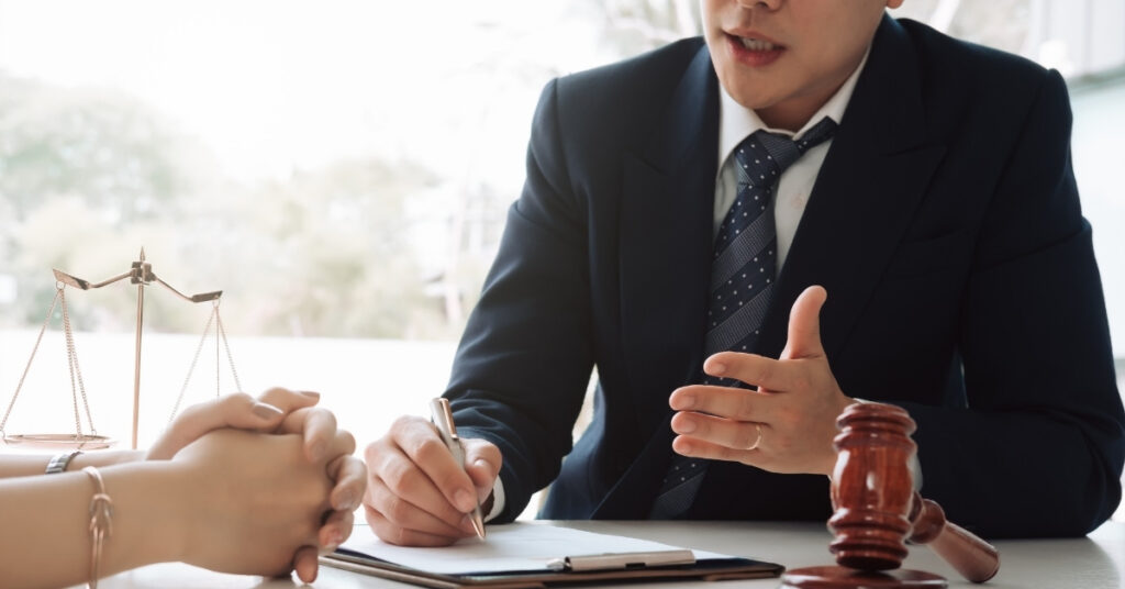 オフィスで依頼者に委任状について説明し、確認する弁護士。