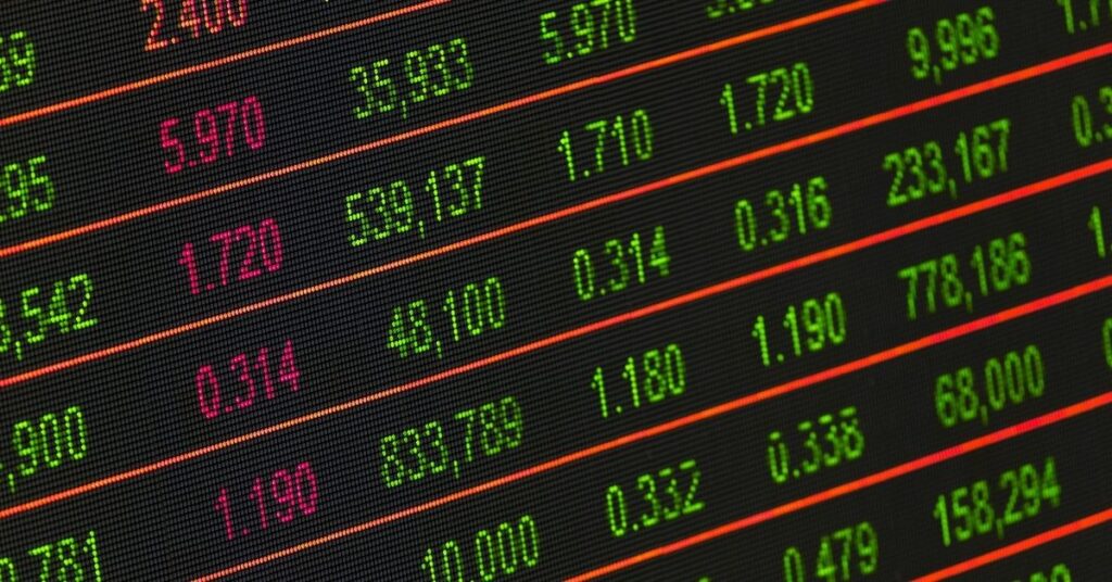 Stock market digital board with numbers and share prices, illustrating capital gains tax in indonesia.