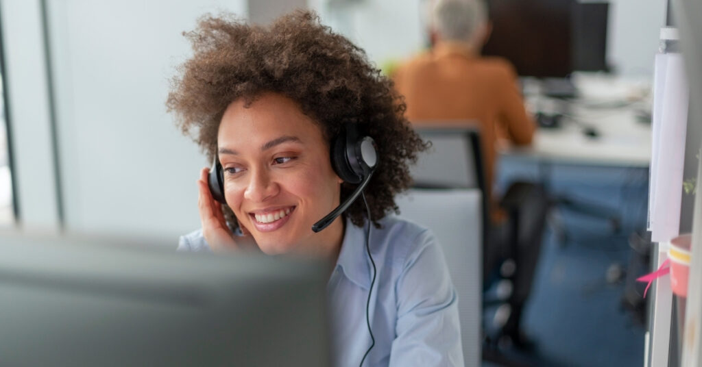 Friendly visa consultant with headset providing online support to fix indonesia e-visa status stuck on waiting verification.