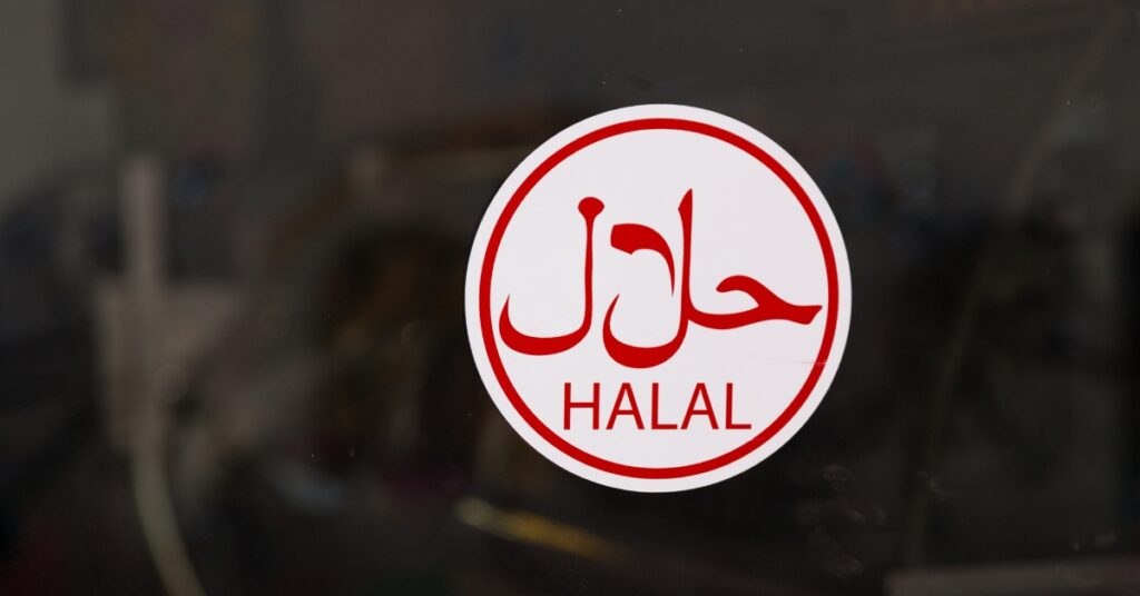 Klistermärke med rödvit halal-certifieringslogotyp på ett glasfönster som visar officiell halal-överensstämmelse för företag i Indonesien.