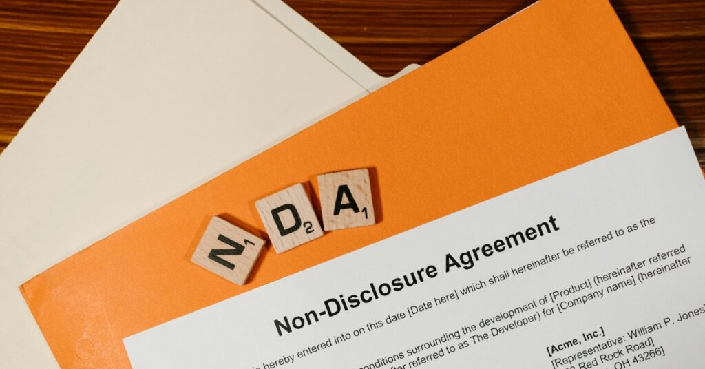 Угода про нерозголошення (nda) - документ з дерев'яними плитками, на яких написано "nda", що свідчить про дотримання законодавства при наймі іноземного персоналу в Індонезії.