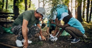 Volunteers planting a tree outdoors, illustrating community service and activities related to the indonesia volunteer visa