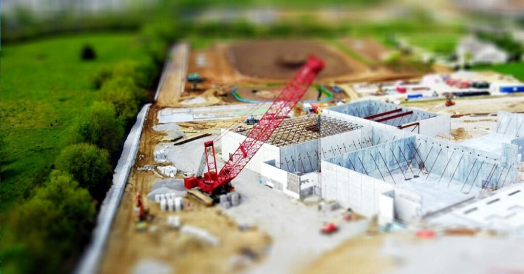 クレーンやコンクリート構造物のある建設現場の航空写真。