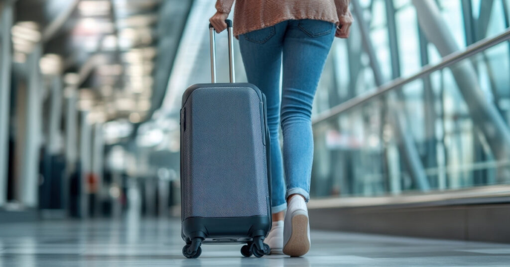 旅客拖著行李箱穿過機場航廈,說明離開印尼前關閉kitap的步驟。.