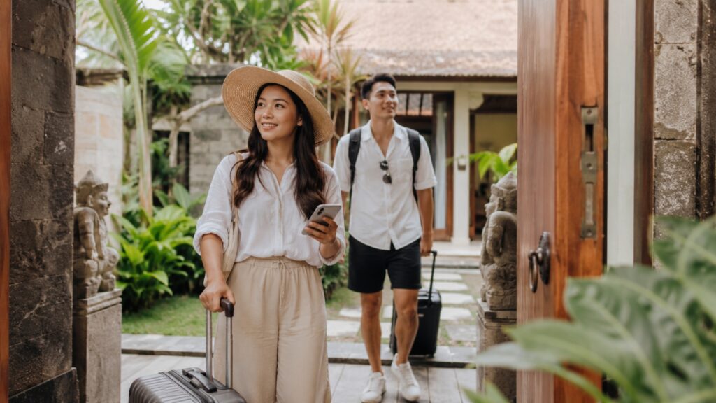 Couple arriving at a bali villa with luggage for a planned trip to indonesia.
