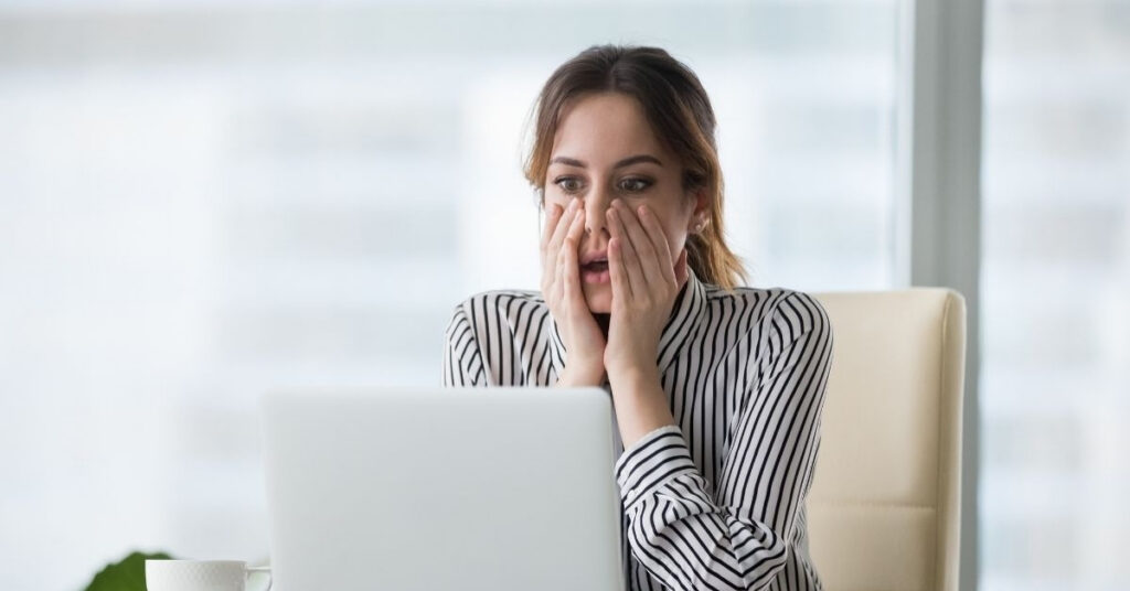 Worried woman staring at laptop after receiving an Indonesia calling visa rejection, learning what went wrong in her application.