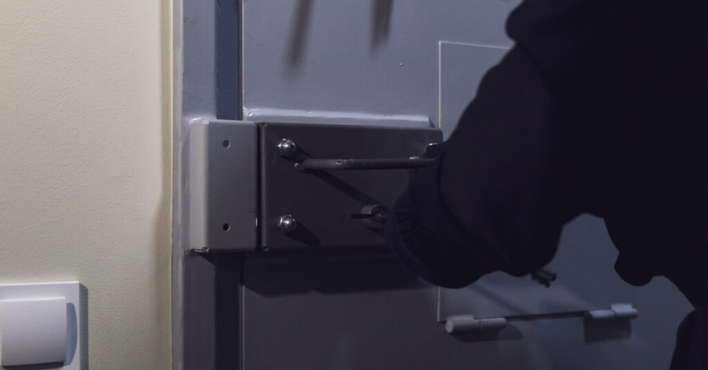 Close-up of a heavy door latch being secured, representing immigration detention during the indonesia deportation process.