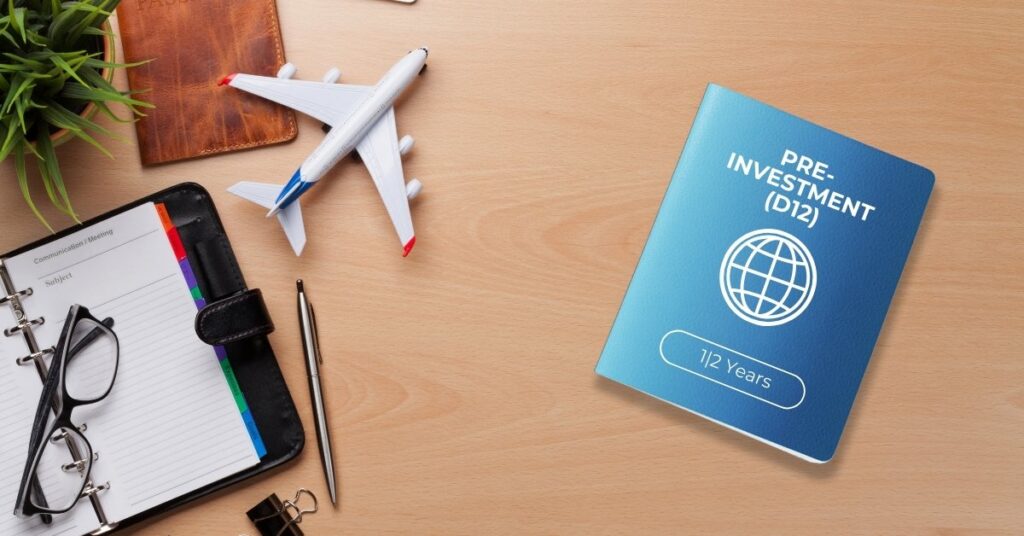 “carta di tipo passaporto ”pre-investimento (d12)" su una scrivania di legno accanto a un taccuino, occhiali, penna, modellino di aeroplano e oggetti da viaggio.