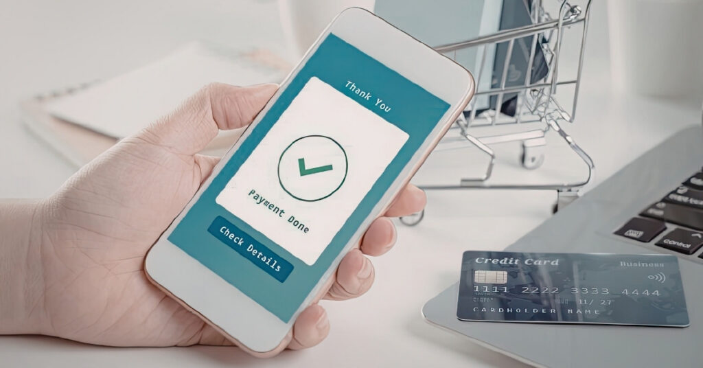 Phone screen showing “payment done” next to a credit card and laptop, confirming a successful indonesia visa payment.