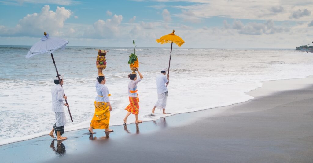 Balinesiske hinduer i traditionelle klæder udfører en havceremoni, der symboliserer det kulturelle liv efter at have fået indonesisk statsborgerskab.