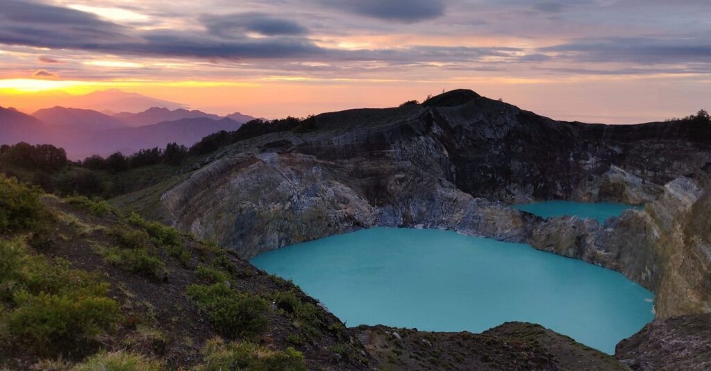 Яскраві бірюзові кратерні озера в Келімуту під час сходу сонця - сюрреалістичне природне диво і одне з найкращих місць в Індонезії для подорожей.
