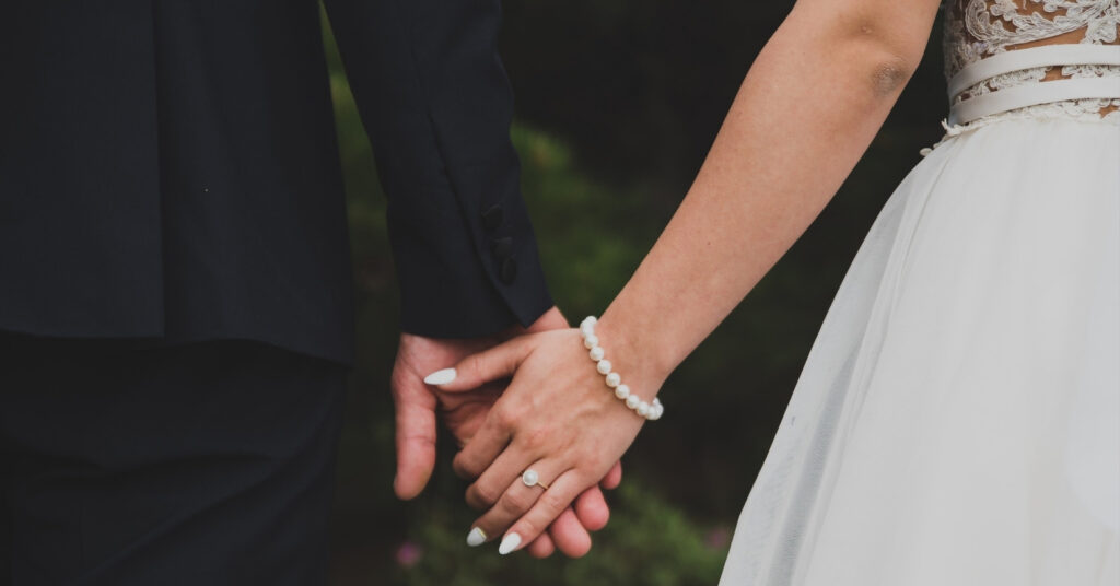 Małżeństwo trzymające się za ręce, ilustrujące ścieżkę małżonków od kitas do kitap w Indonezji.