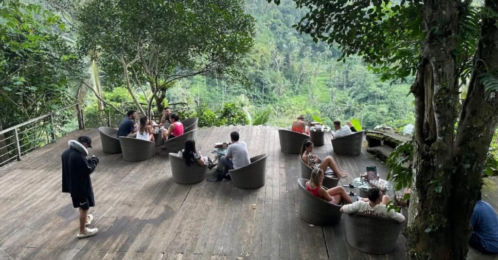 Des visiteurs se détendent dans la plantation de café de Kumulilir à ubud, surplombant la jungle luxuriante et les rizières en terrasses de Bali.