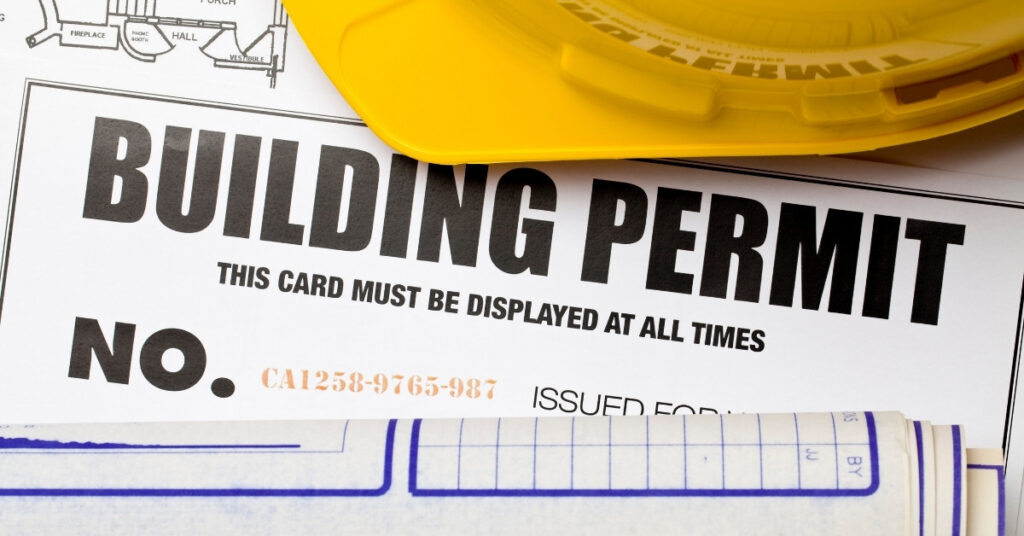 Building permit document with yellow hard hat and plans for an indonesia building permit article