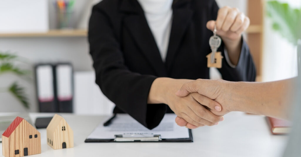 Property agent handing house keys to a renter, representing long-term villa rental contracts in bali.