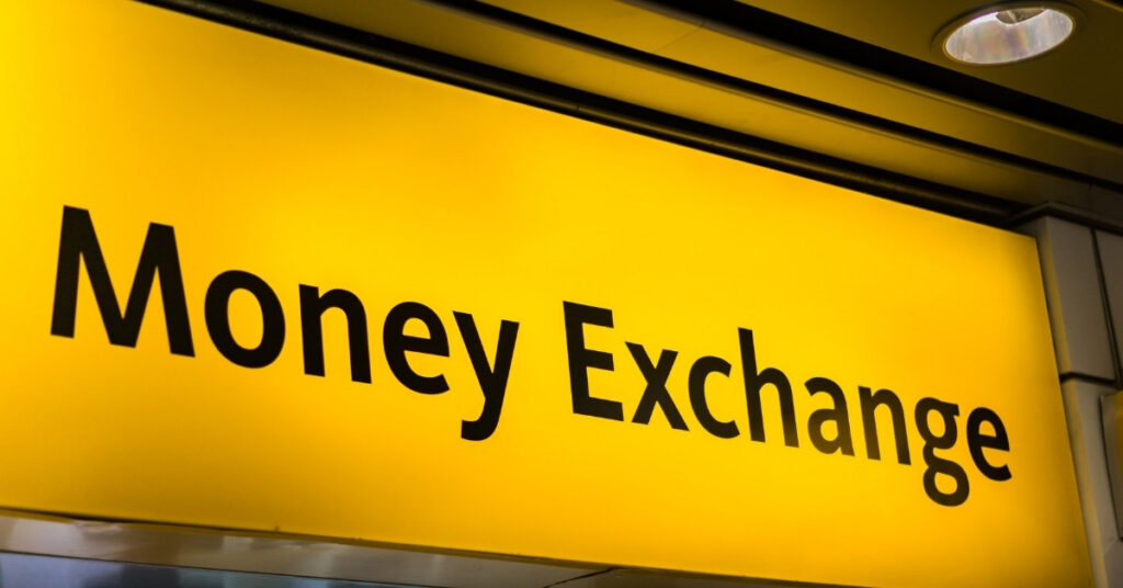 Яскраво-жовта вивіска з написом "обмін грошей" в аеропорту або торговому центрі в Балі.