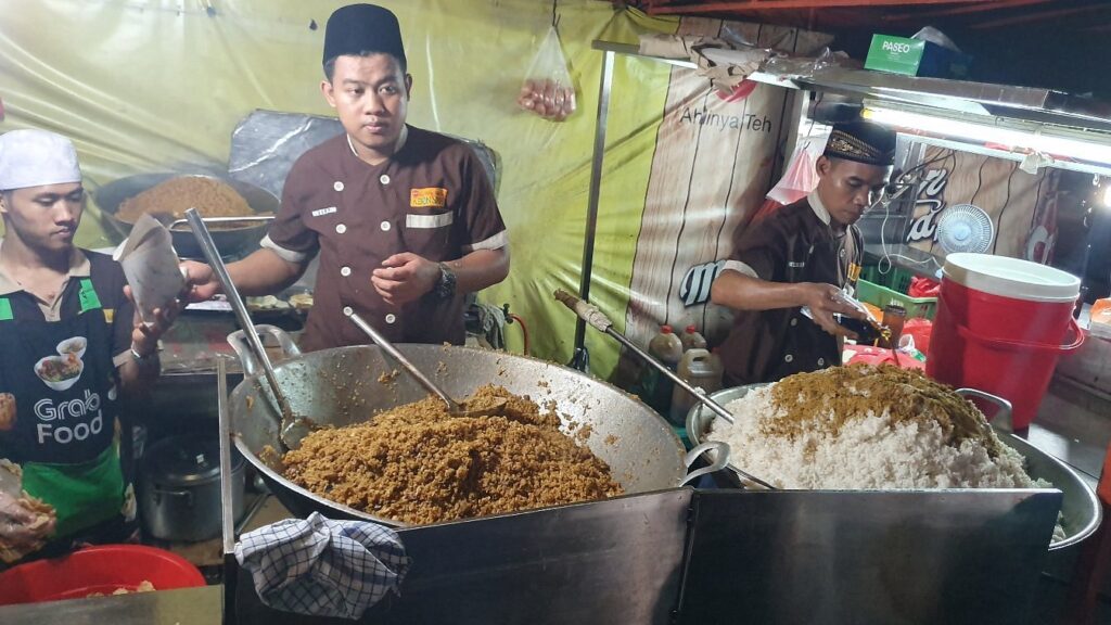 Продавці вуличної їжі готують величезні порції смаженого рису в nasi goreng kebon sirih, кулінарному місці, яке обов'язково варто відвідати серед нічних визначних пам'яток Джакарти