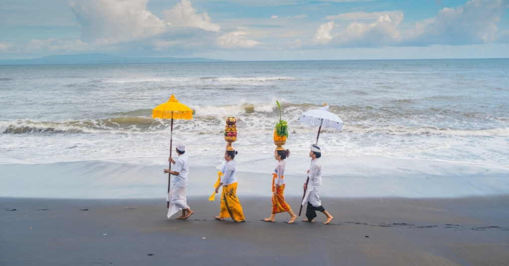 Ceremonia balinesa en la playa que muestra la cultura local en bali: es importante respetar los actos sagrados en los que puede estar restringida la venta de alcohol o el consumo público.