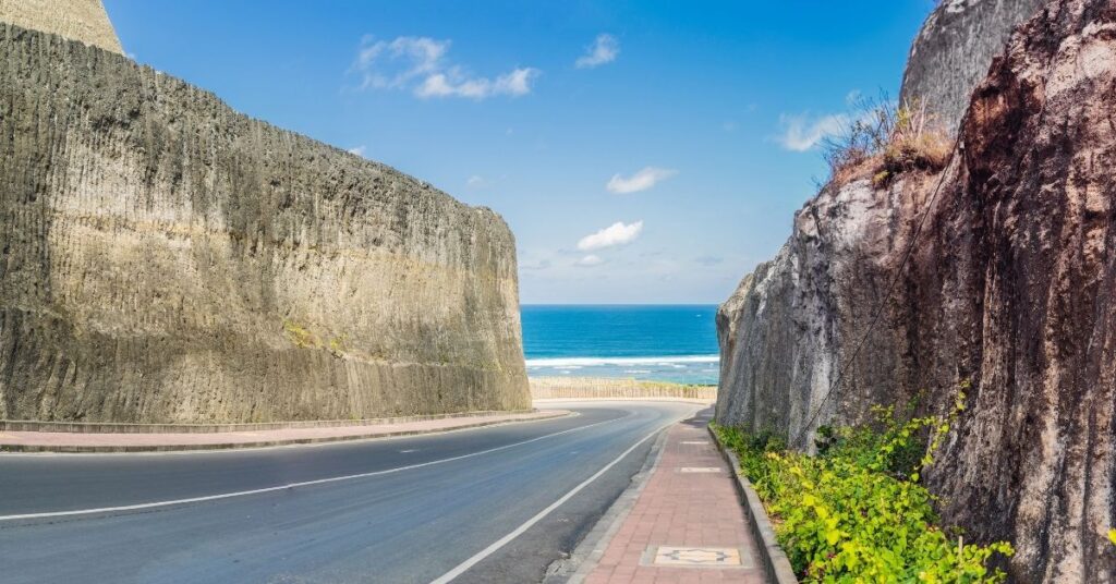 Smooth coastal road between limestone cliffs with ocean view in south bali. A beginner-friendly scooter route.