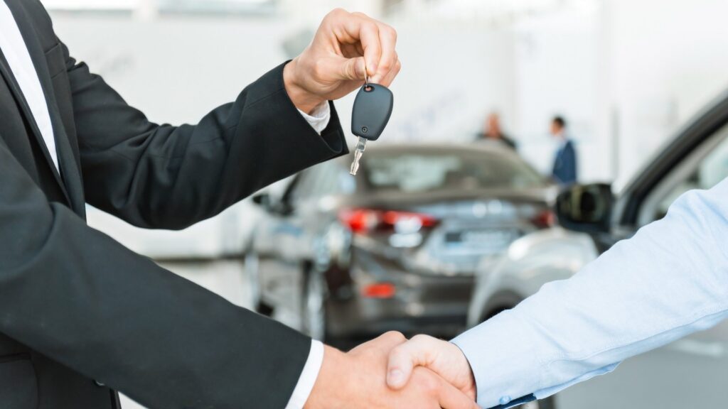 Car key handover at a dealership, showing how sktt can support vehicle registration for foreigners in indonesia.
