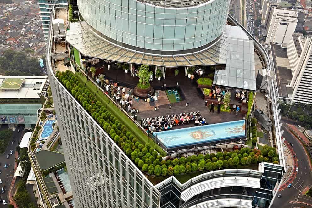 Обідня зона на даху з басейном і видом на місто в барі-ресторані Skye, одній з кулінарних визначних пам'яток Джакарти