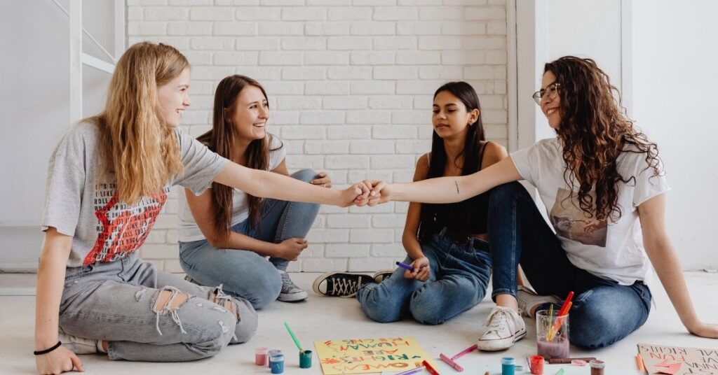 Group of international students laughing and painting together, illustrating permitted activities on an indonesia student exchange visa