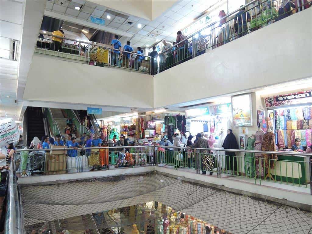 Жвавий інтер'єр текстильного ринку Танах Абанг з яскравими кіосками з тканинами та покупцями - жваве місце для шопінгу та одна з комерційних визначних пам'яток Джакарти.