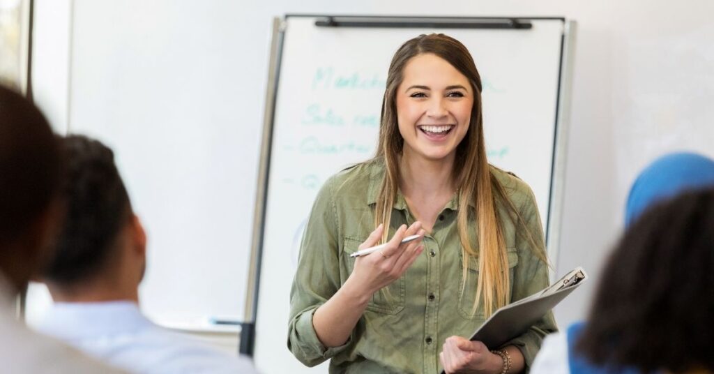 Female trainer leading a team workshop in front of a whiteboard, representing onboarding and developing Indonesian staff.