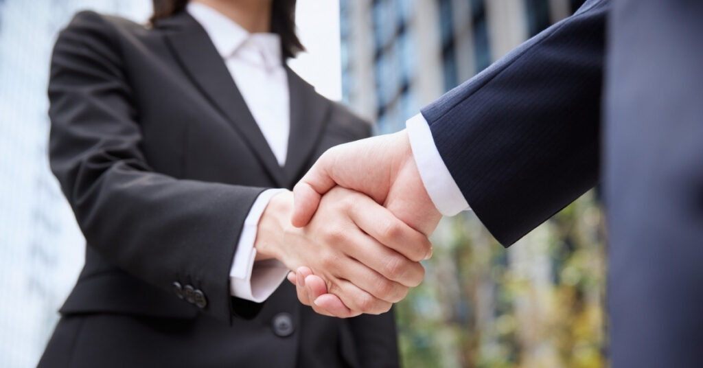Business partners shaking hands, symbolizing legal business registration and nib compliance in indonesia.