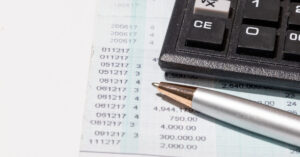 Close-up of a bank statement with a calculator and pen, highlighting a three-month statement used as proof of funds.