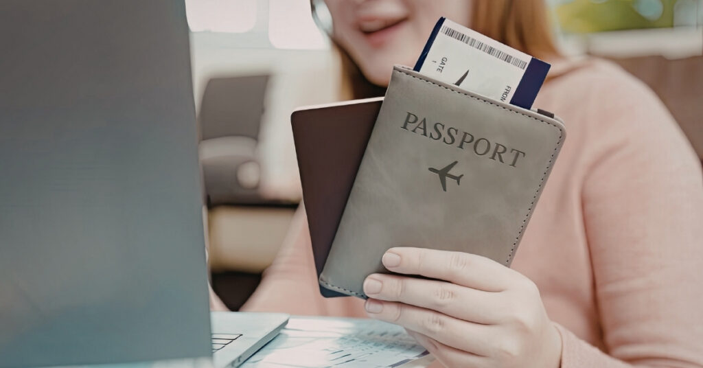 Traveler holding a passport and boarding pass by a laptop—prepare travel documents and a personal bank statement for an indonesia visa for musician.