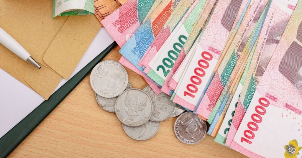 Stacks of Indonesian rupiah cash, costly overstay fines from repeating Indonesia VOA violations.