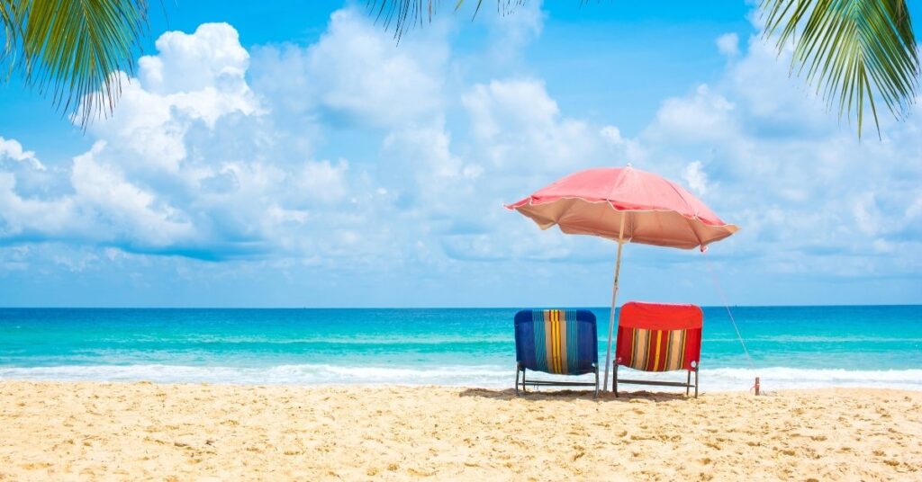 Beach chairs under umbrella symbolizing trips over 60 days beyond Indonesia VOA limits