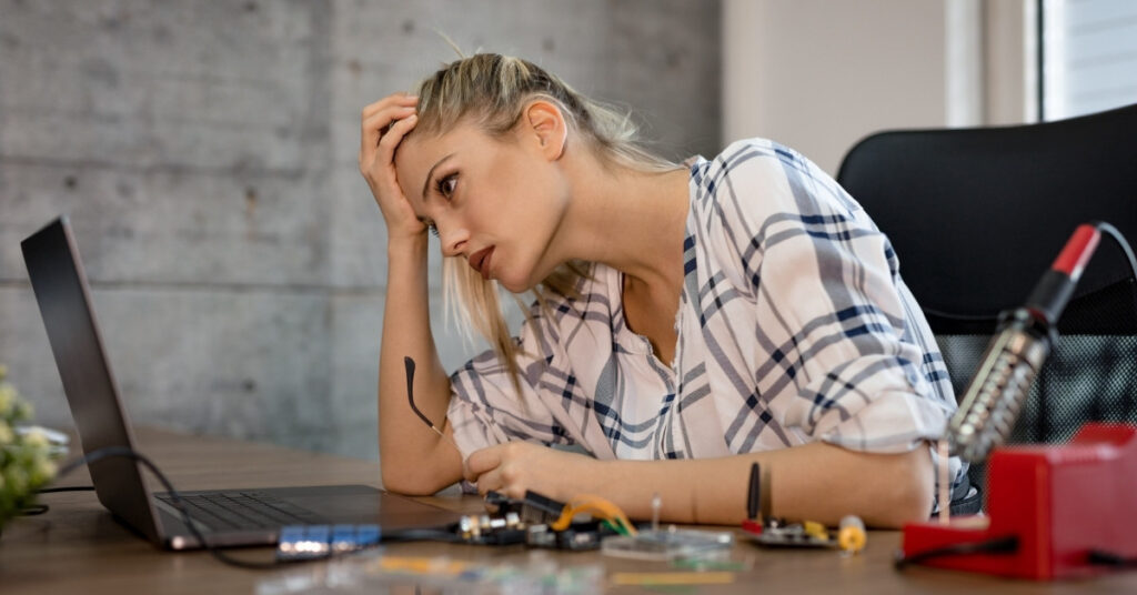 Stressed remote worker at laptop, using a VOA for work is the wrong visa purpose.