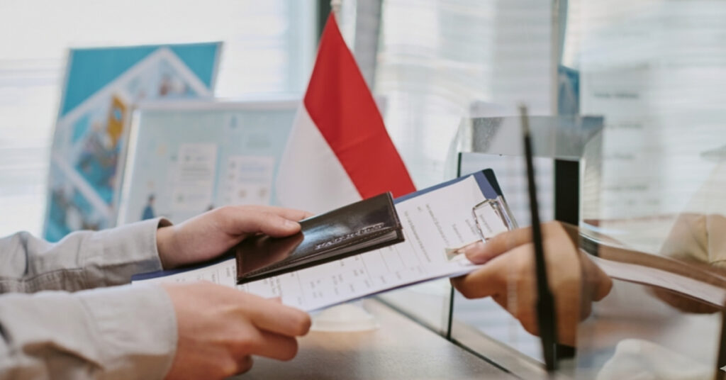 Visa-indonesia team handing passport and visa documents to indonesian immigration officer to resolve e-visa waiting verification status.