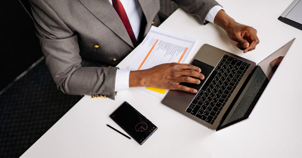 Businessperson at a laptop with paperwork, preparing an oss submission for indonesia’s nib business registration number.