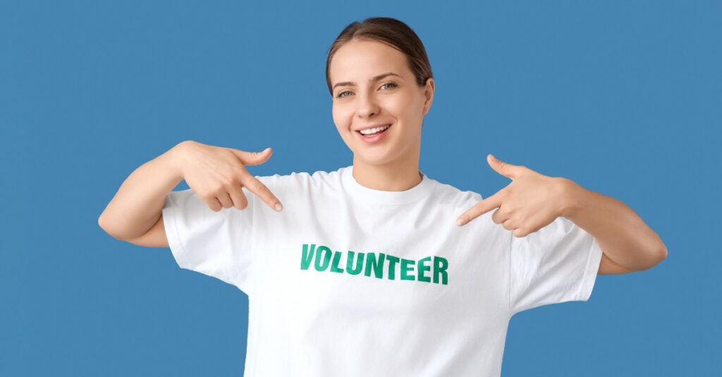 年轻女子指着一件志愿者衬衫，代表印尼志愿者签证的对象